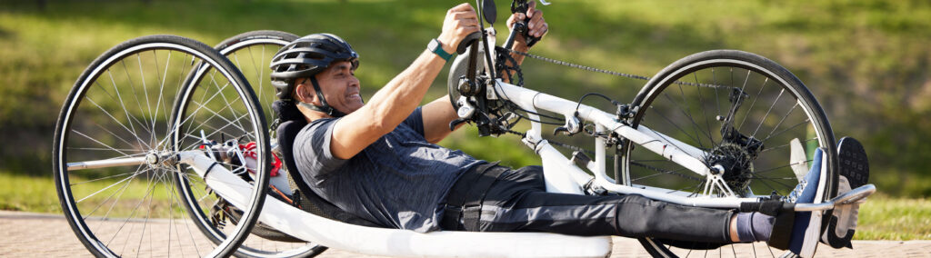 A man uses an adaptive bicycle.