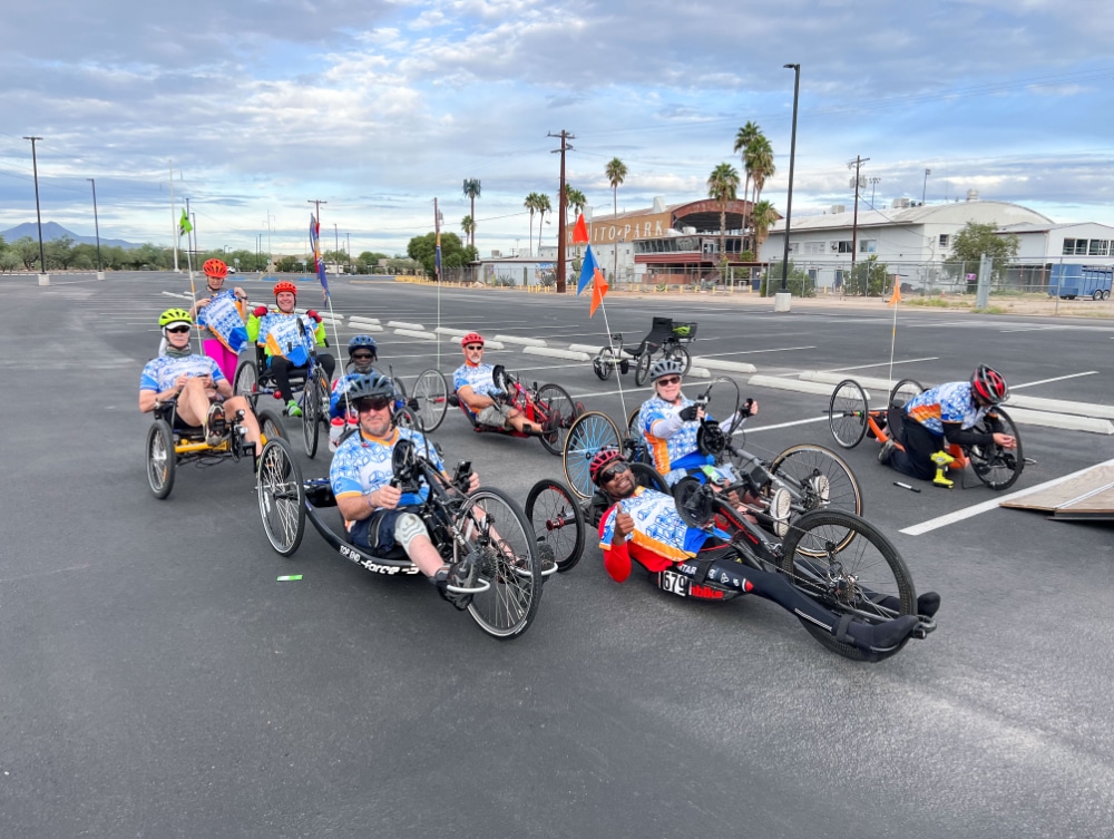 Adaptive cyclists gather in a parking lot before the Loop de Loop community ride.
