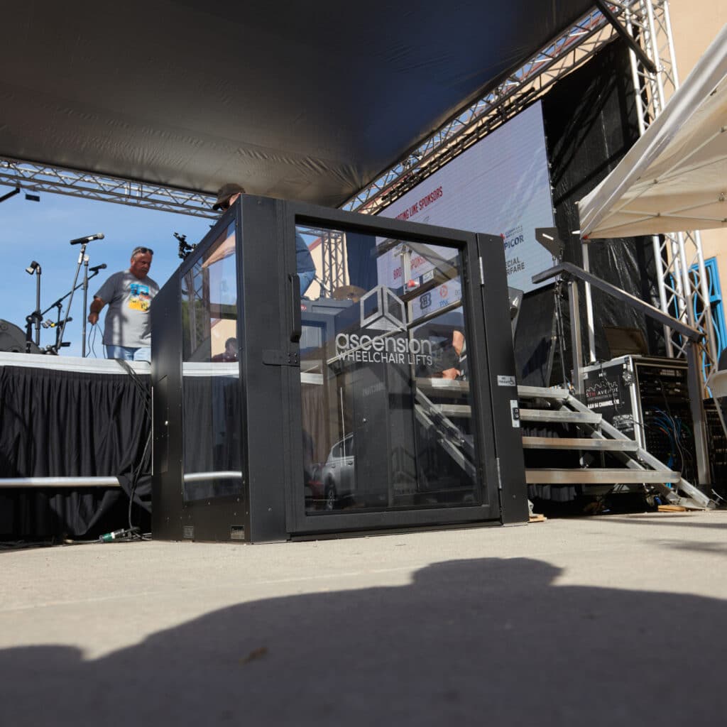 Ascension Wheelchair Lift installed beside an outdoor stage, providing accessible access for performers and speakers.
